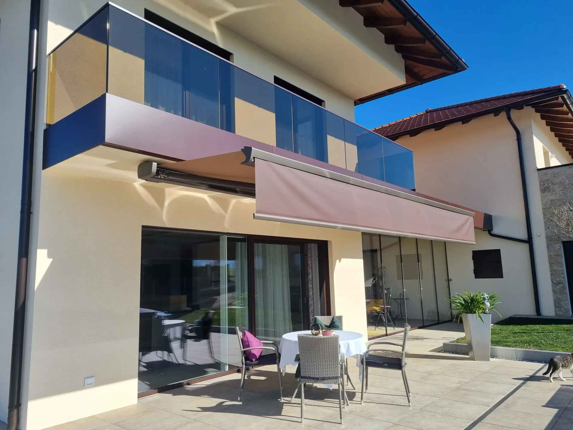 Ein Haus mit einem Balkon mit einem Tisch und Stühlen darunter