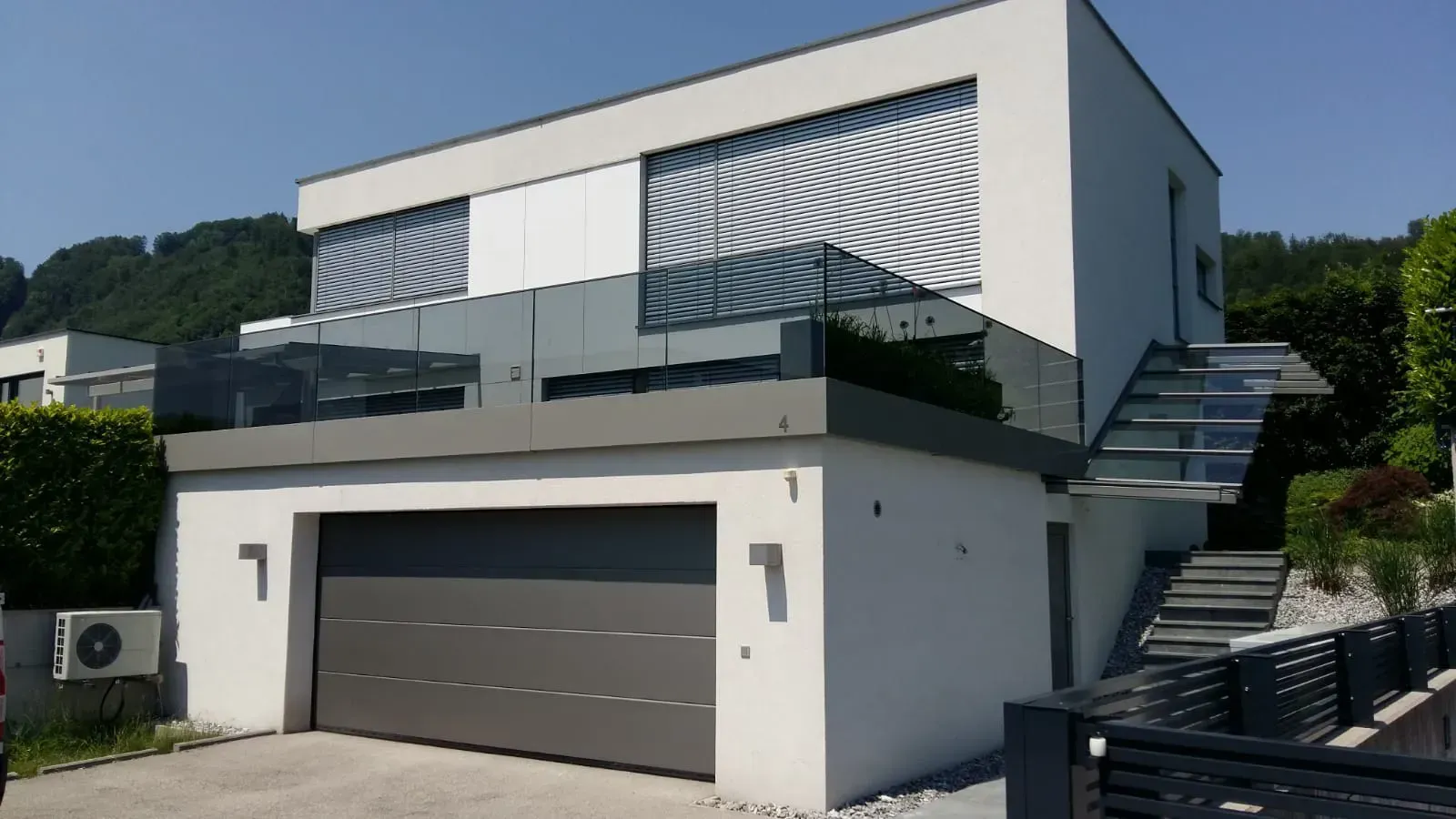 Ein modernes Haus mit einer Garage und einer Treppe, die dorthin führt