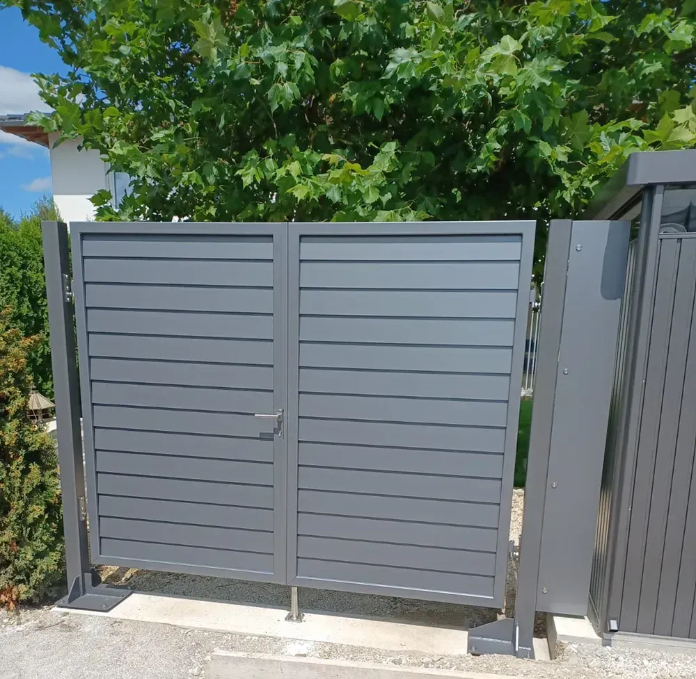 Ein graues Tor mit einem Baum im Hintergrund