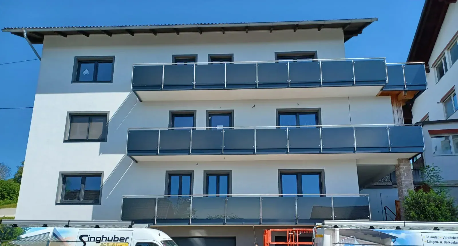 Ein weißes Gebäude mit vielen Fenstern und Balkonen