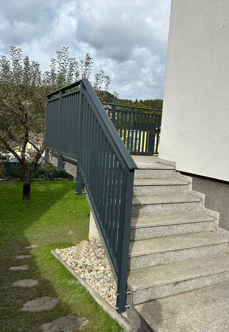 Eine Treppe, die zu einem Haus mit einem Metallgeländer hinaufführt.