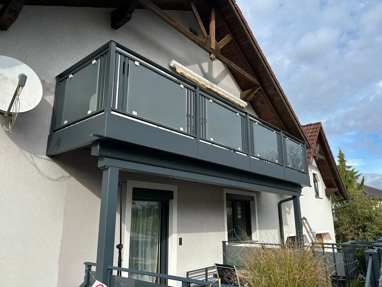 Ein Balkon an der Seite eines Hauses mit einer Satellitenschüssel.