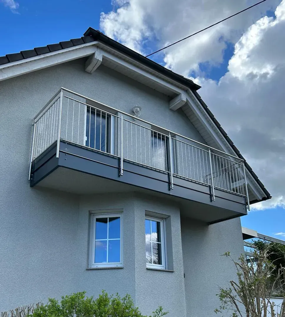 Ein Haus mit einem Balkon auf dem Dach