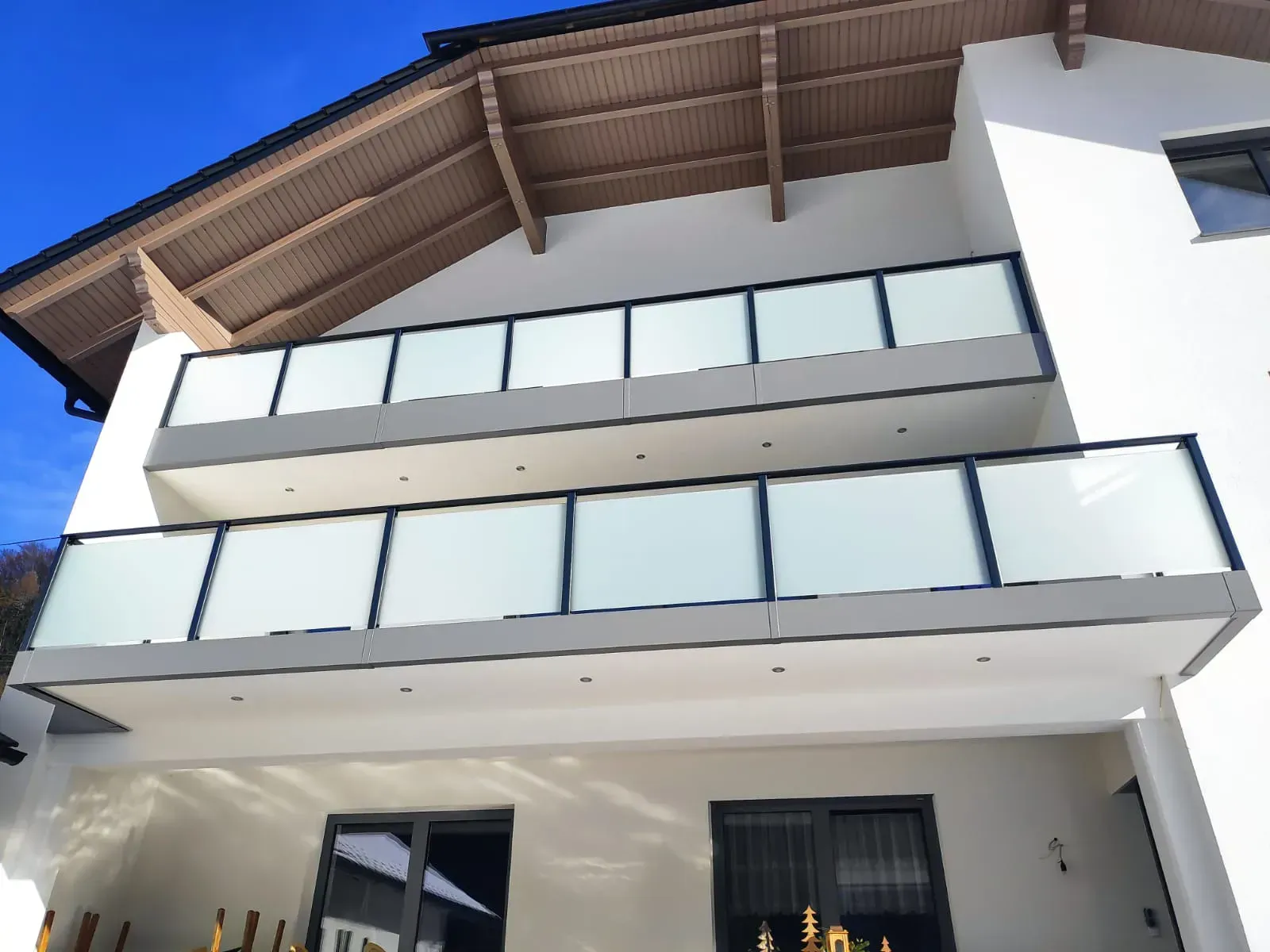 Ein weißes Gebäude mit einem Balkon und einem blauen Himmel im Hintergrund