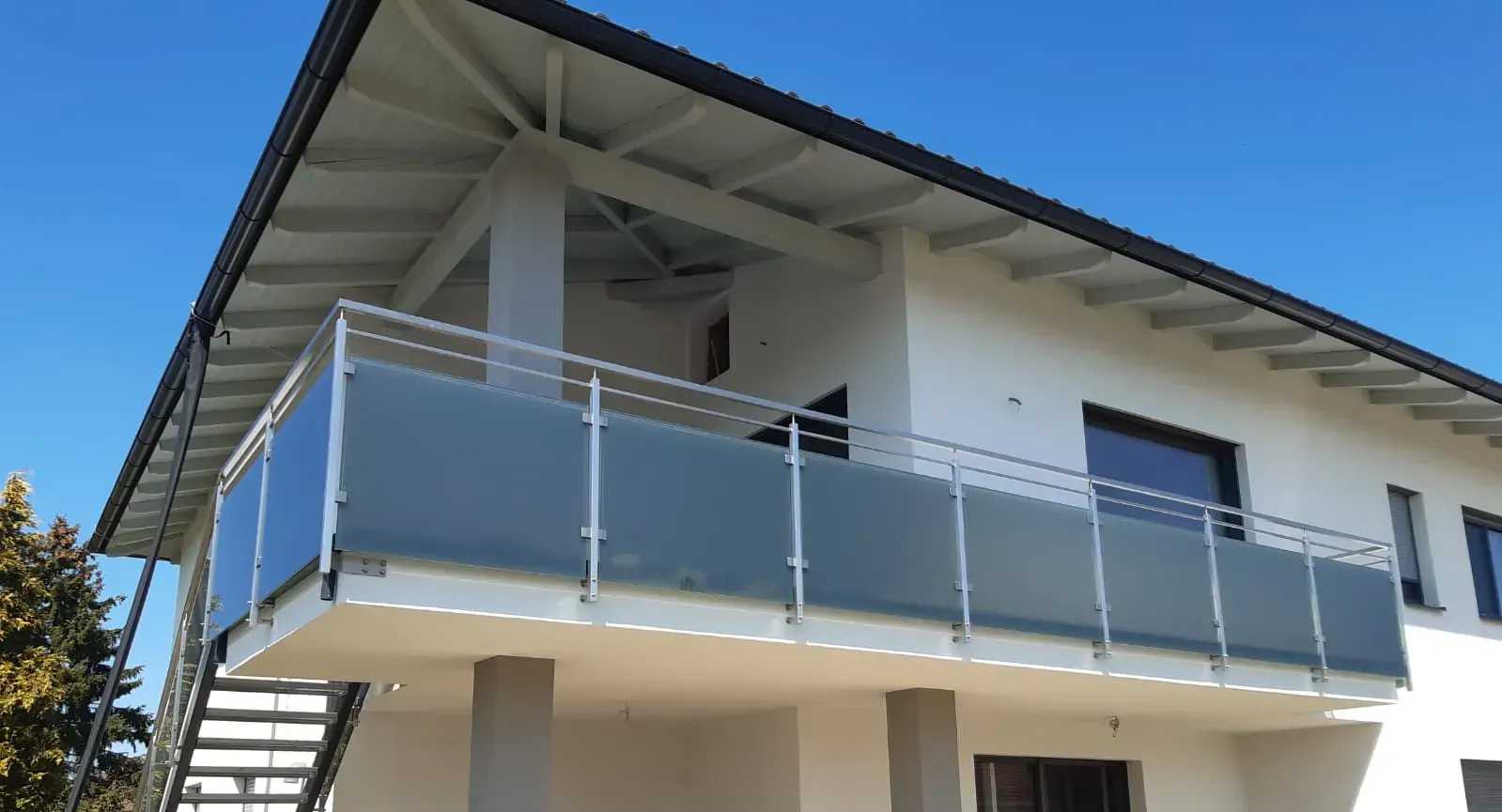 Ein weißes Haus mit Balkon und Treppe