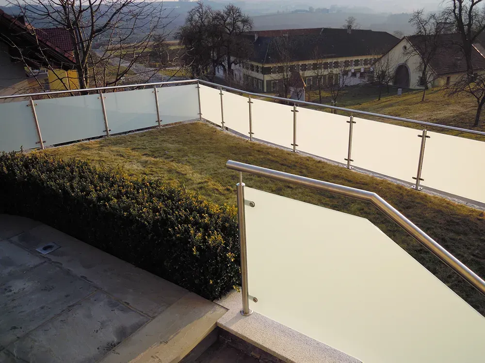 Ein Balkon mit Edelstahlgeländer und Glaszaun