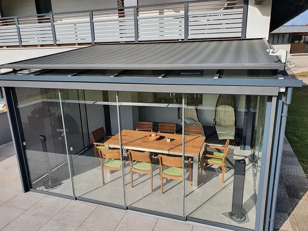 Eine Terrasse mit Tisch und Stühlen unter einem Baldachin.