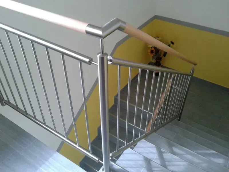 Eine Treppe mit einem Edelstahlgeländer und einer gelben Wand