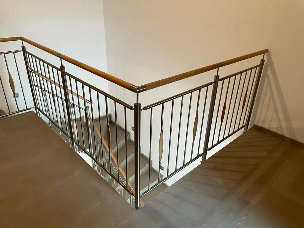 Eine Treppe mit Metallgeländer und Holzhandläufen.