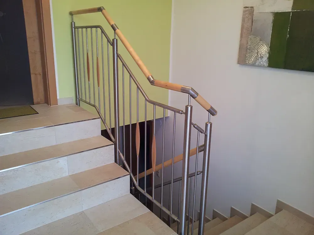 Eine Treppe mit Edelstahlgeländer und Holzhandlauf
