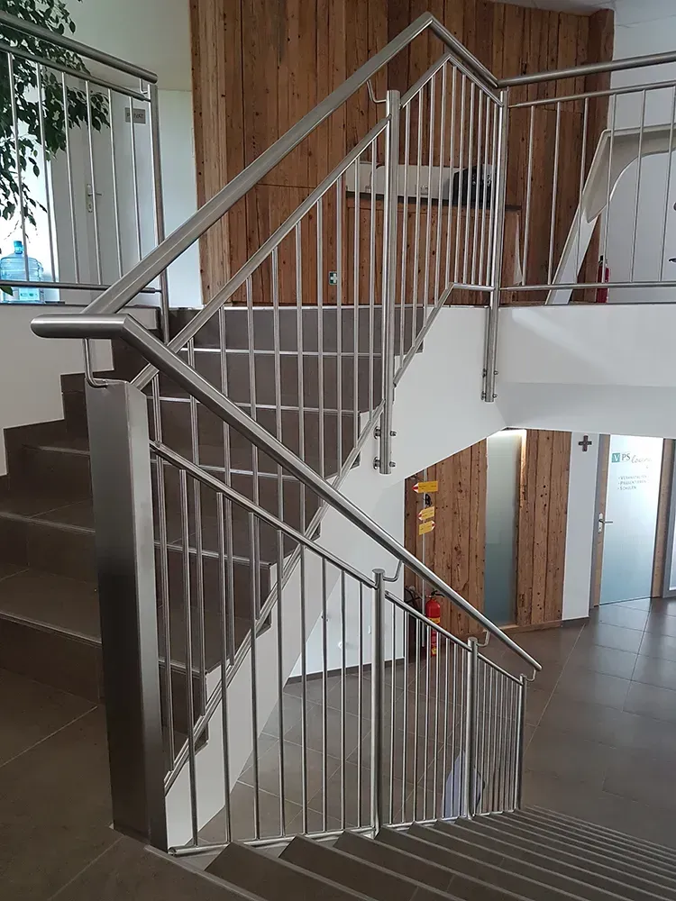 Eine Treppe mit einem Edelstahlgeländer in einem Gebäude