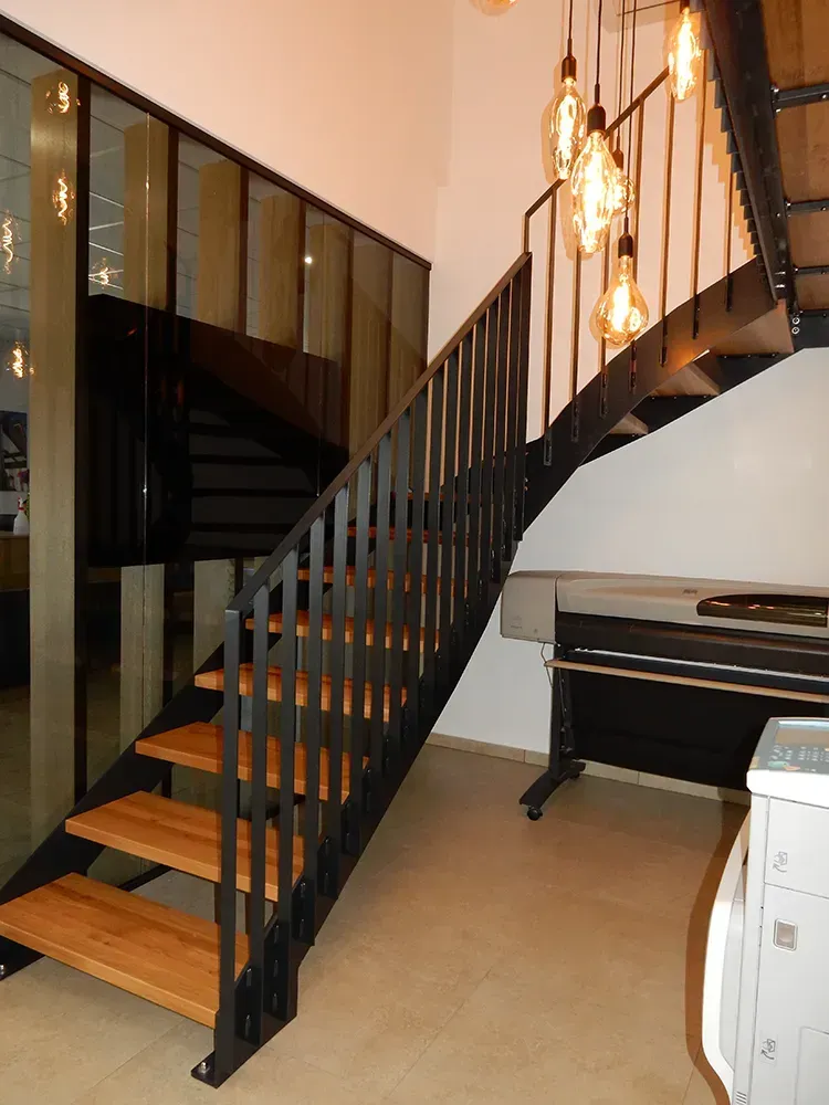 Eine Treppe mit Holzstufen und einem schwarzen Geländer