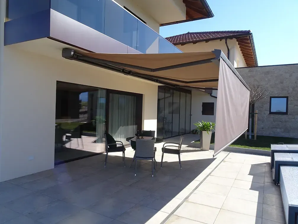 Eine Terrasse mit Tisch und Stühlen unter einer Markise