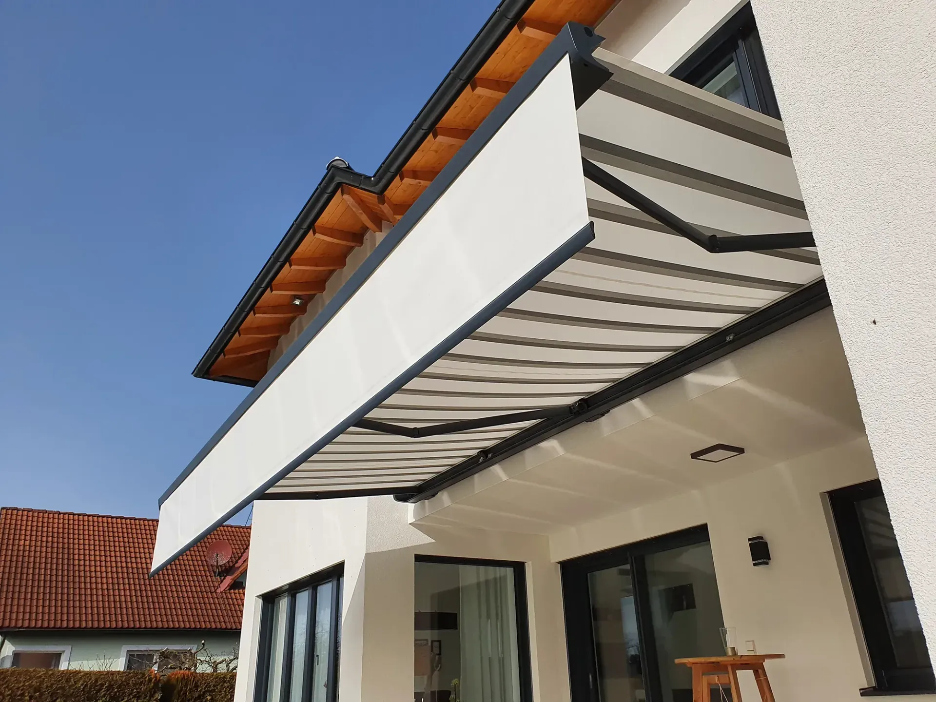 Ein Haus mit einer weißen Markise an der Seite.