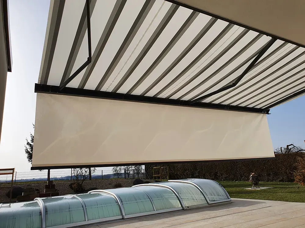 Über einem Swimmingpool hängt eine weiße Markise.