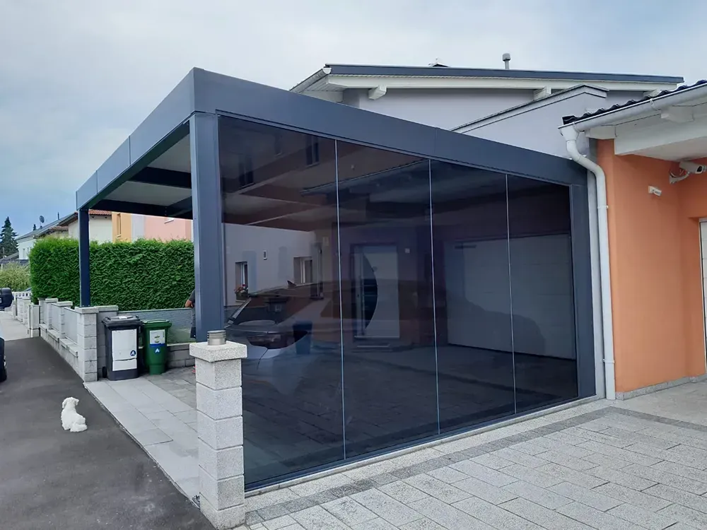 Ein Auto ist unter einem Vordach vor einem Haus geparkt.