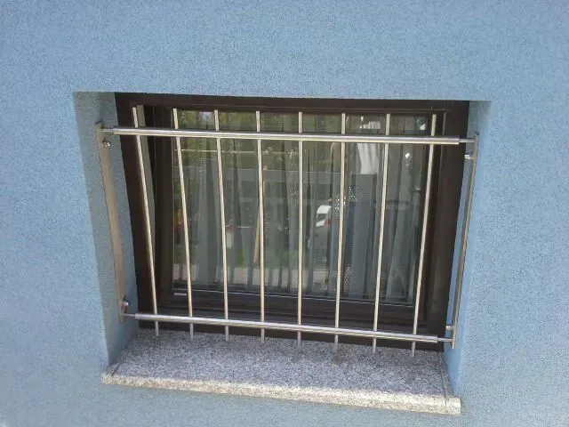 Ein Fenster mit einem Edelstahlzaun darum