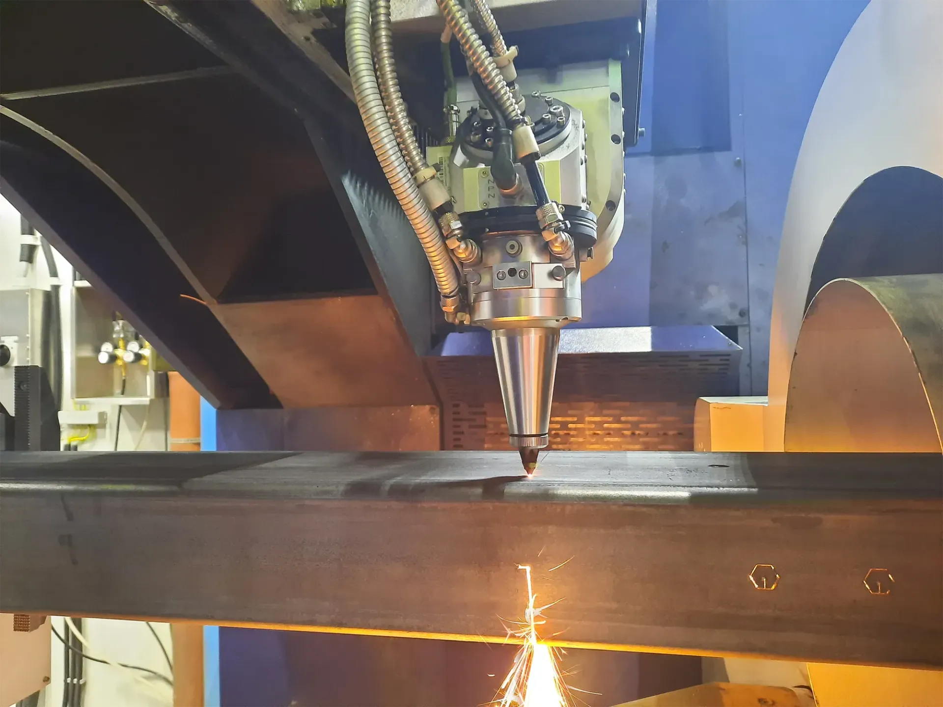 Eine Maschine schneidet ein Stück Metall, wobei Funken entstehen.