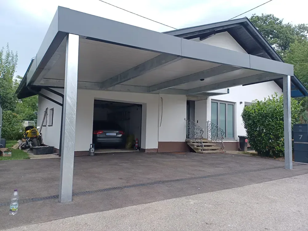 Ein Auto ist unter einem Carport vor einem Haus geparkt.