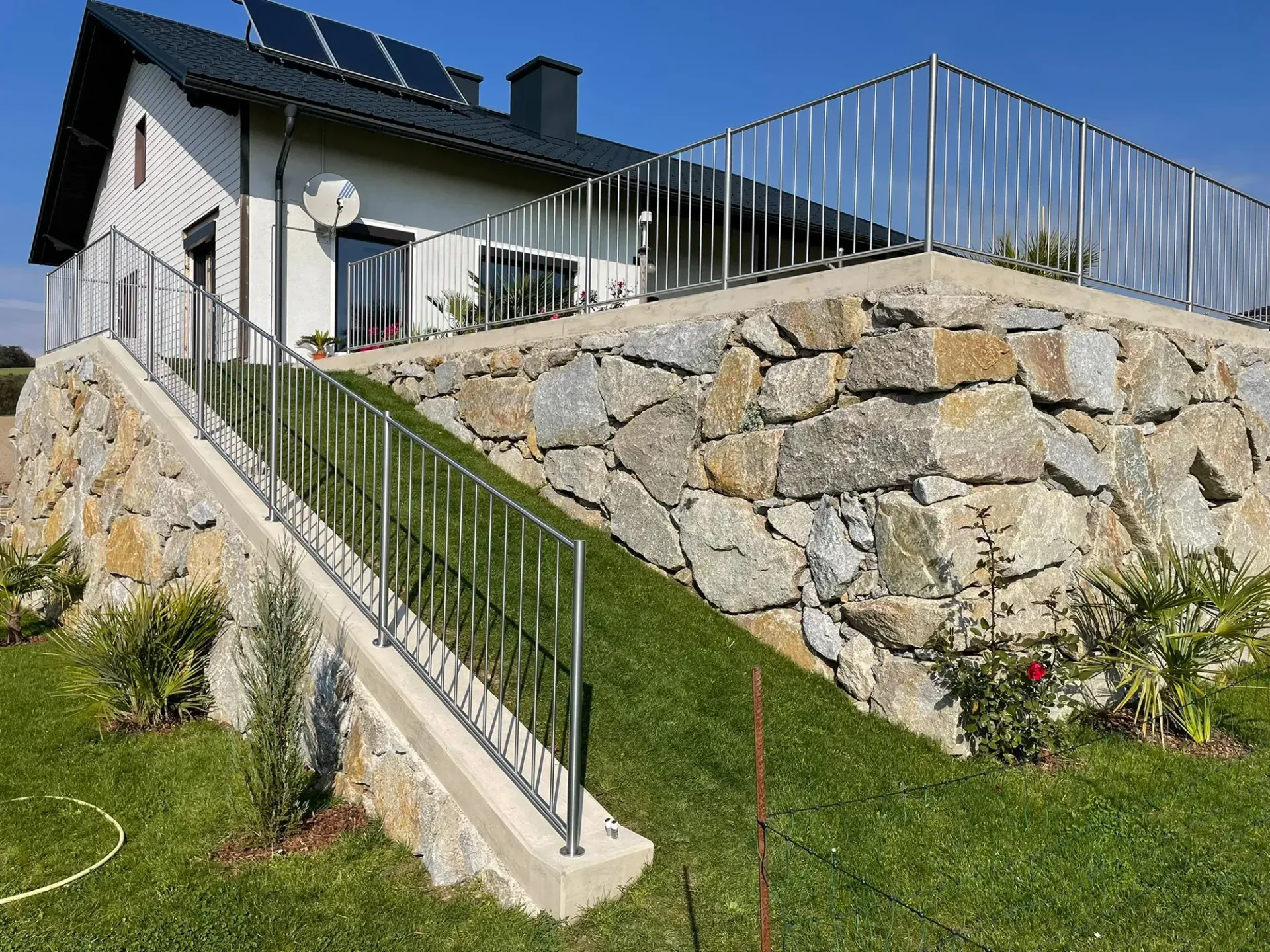 Ein Haus mit einer Steinmauer und einer Treppe, die hinaufführt.