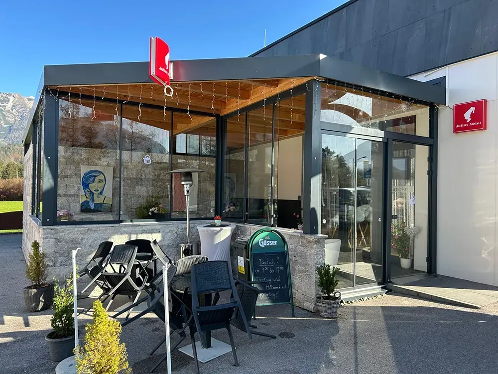 Ein Restaurant mit Tischen und Stühlen draußen.