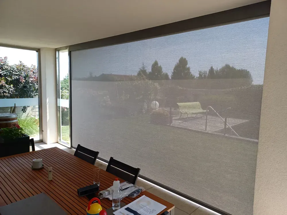 Ein Esszimmer mit Tisch und Stühlen und einem großen Fenster.