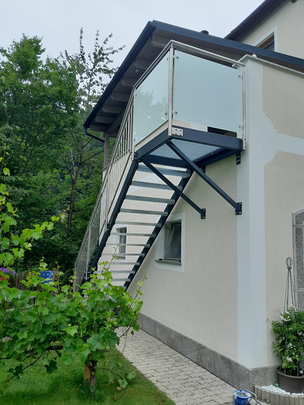 Ein weißes Haus mit einer Treppe, die zu einem Balkon führt