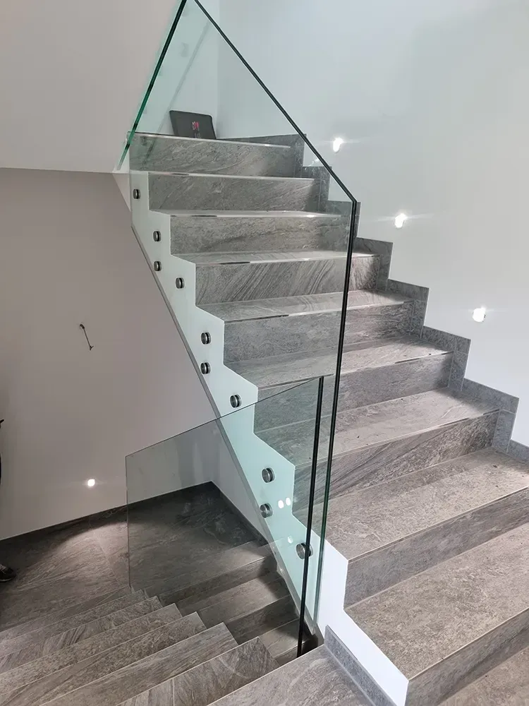Eine Treppe mit einem Glasgeländer in einem Haus.
