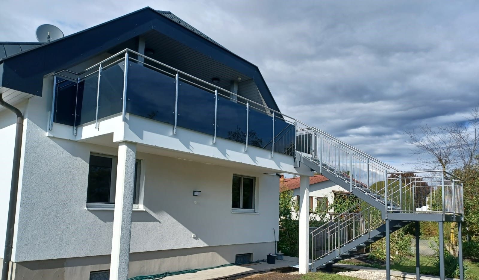 Ein weißes Haus mit Balkon und Treppe