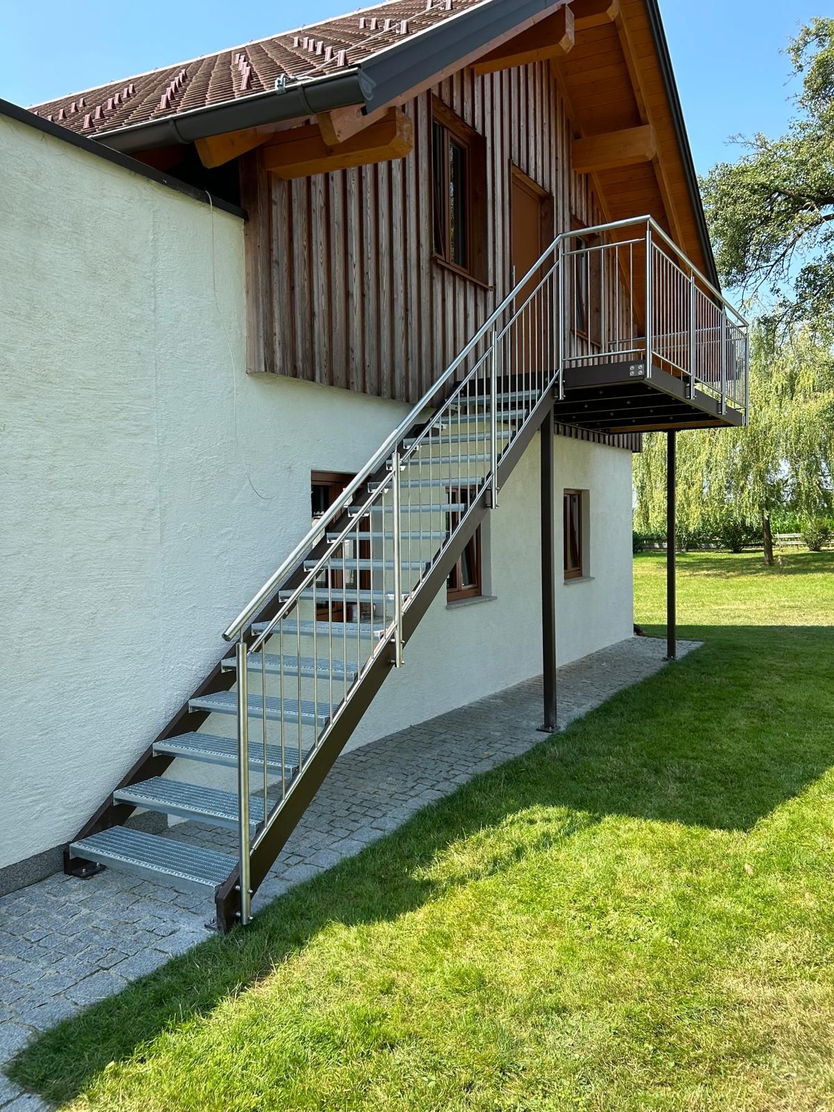 Ein Haus mit einer Treppe, die zu einem Balkon an der Seite hinaufführt.