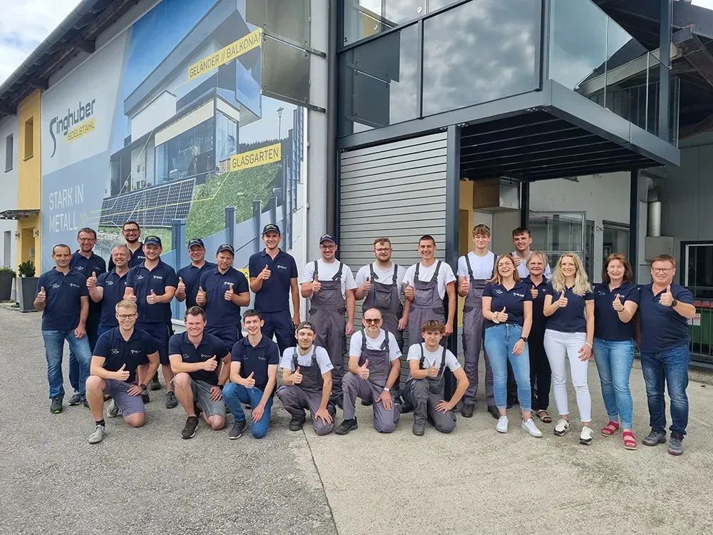 Eine große Gruppe von Menschen posiert vor einem Gebäude für ein Foto.