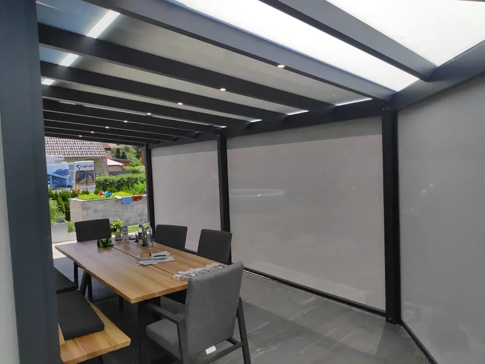 Eine Terrasse mit Tisch und Stühlen unter einer Pergola.