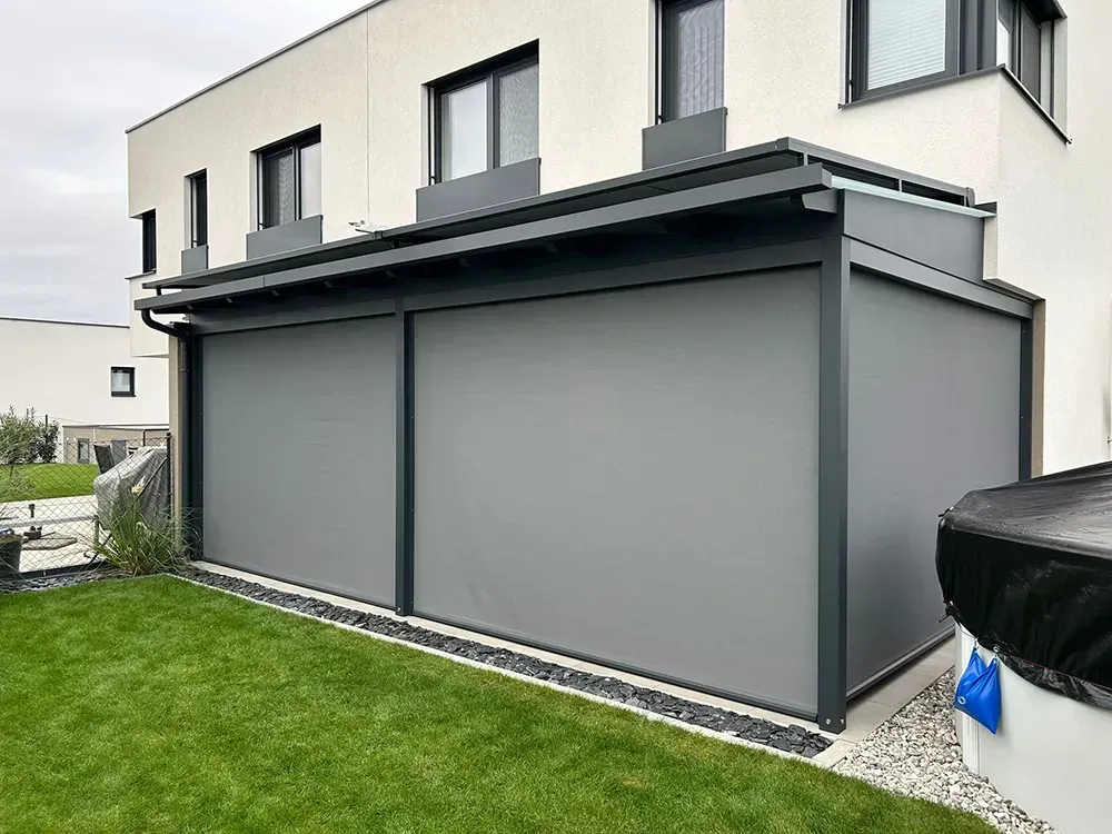 Ein Haus mit einer grauen Markise an der Seite.