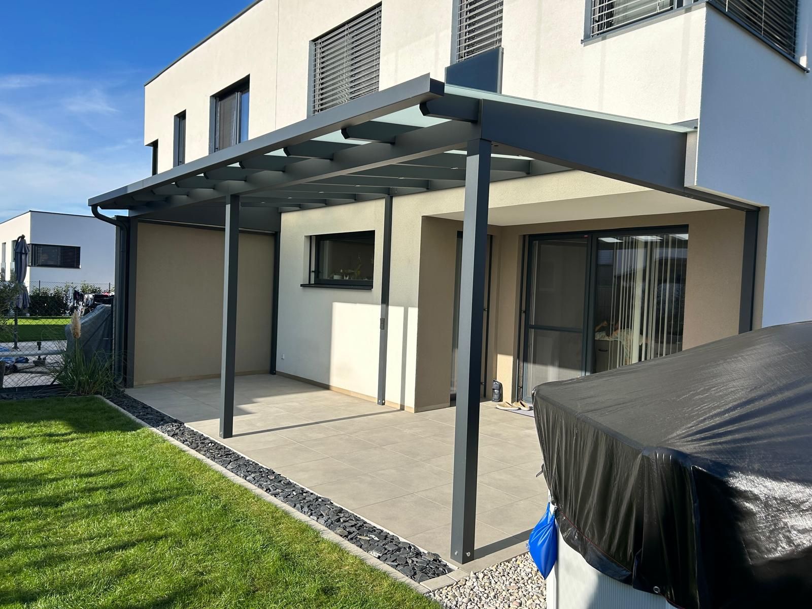 Ein Haus mit einer überdachten Terrasse davor.