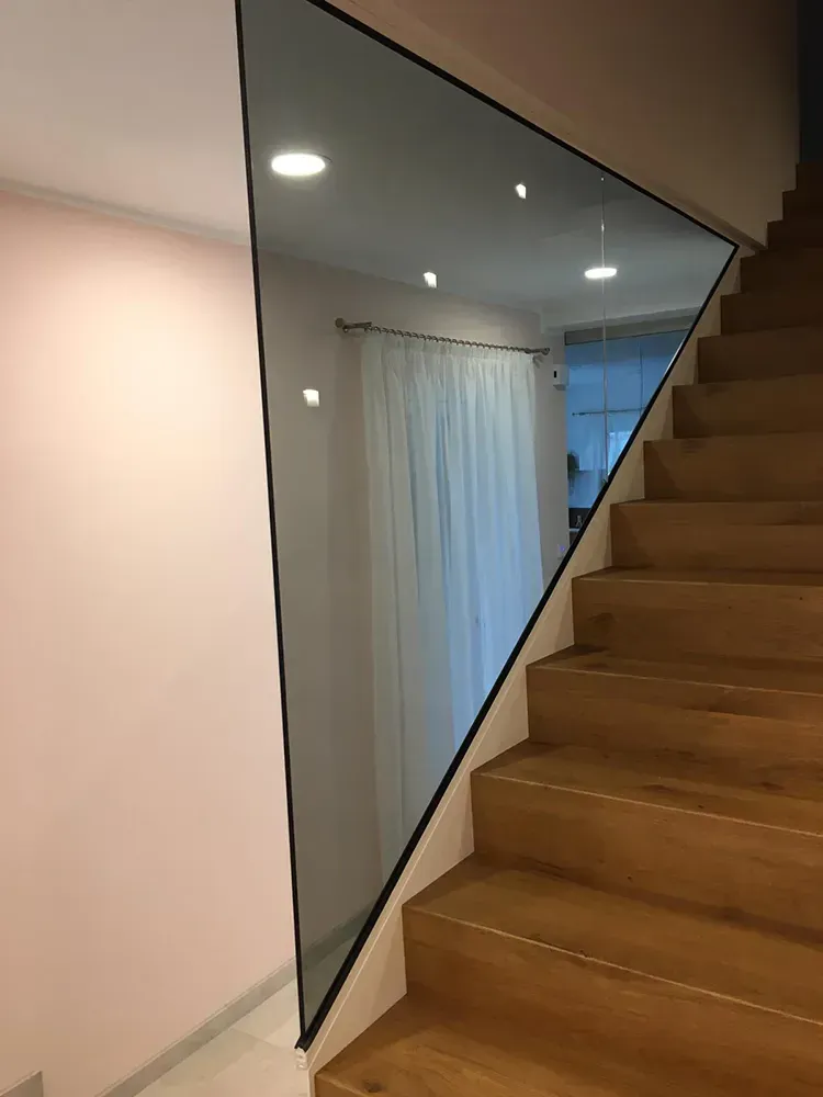 Eine Treppe mit Holzstufen und einem Glasgeländer.