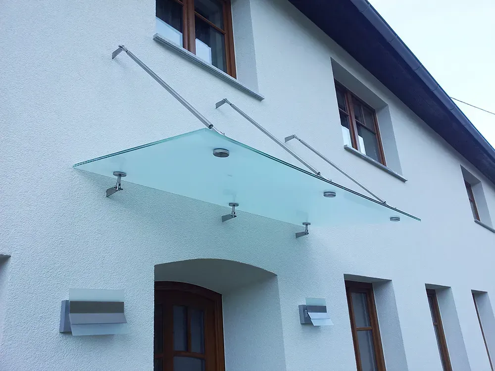 Ein weißes Gebäude mit einem Glasdach über der Tür