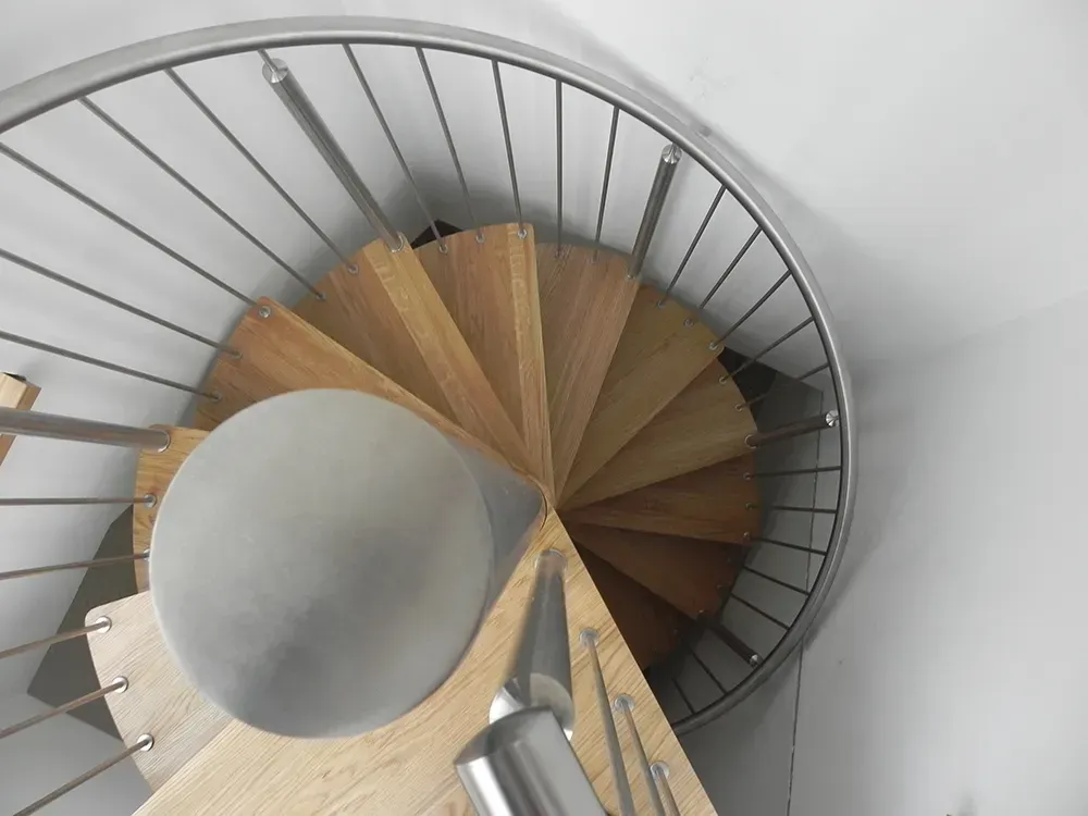 Eine Wendeltreppe mit Holzstufen und einem Metallgeländer