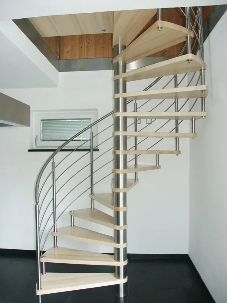 Eine Wendeltreppe mit Holzstufen und Edelstahlgeländer