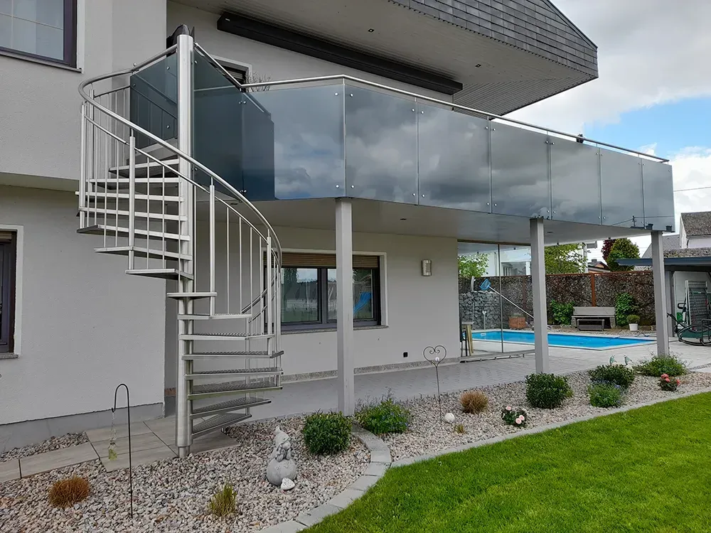 Ein Haus mit einer Wendeltreppe und einem Glasgeländer.
