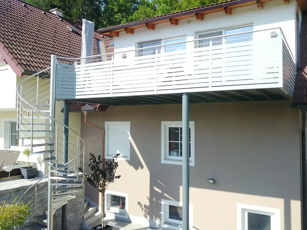 Ein Haus mit Balkon und Wendeltreppe