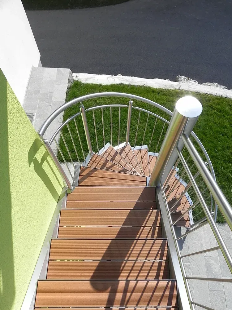 Eine Wendeltreppe mit Holzstufen und Edelstahlgeländer