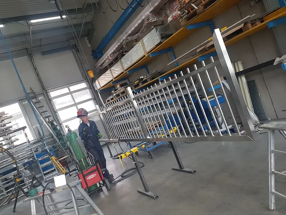 Ein Mann schweißt in einer Fabrik einen Metallzaun.