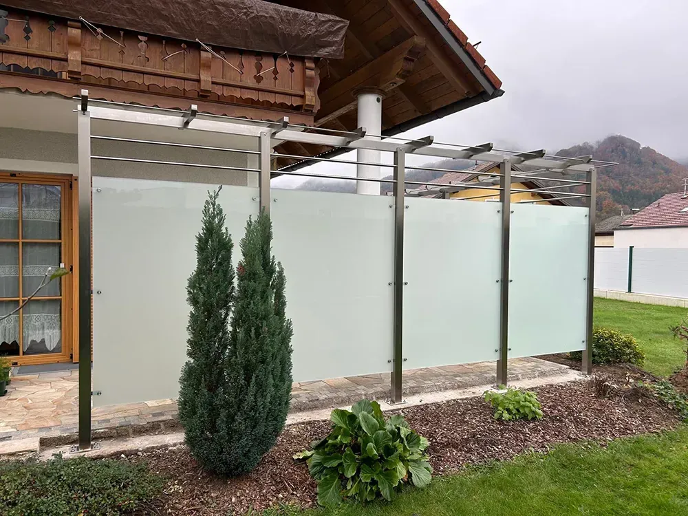 Ein Haus mit einem Glaszaun davor.