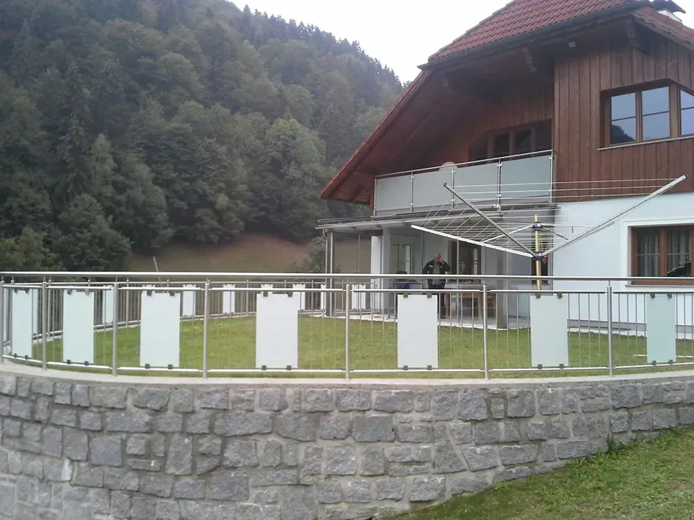 Ein Haus mit einer Ziegelwand und einem Edelstahlgeländer