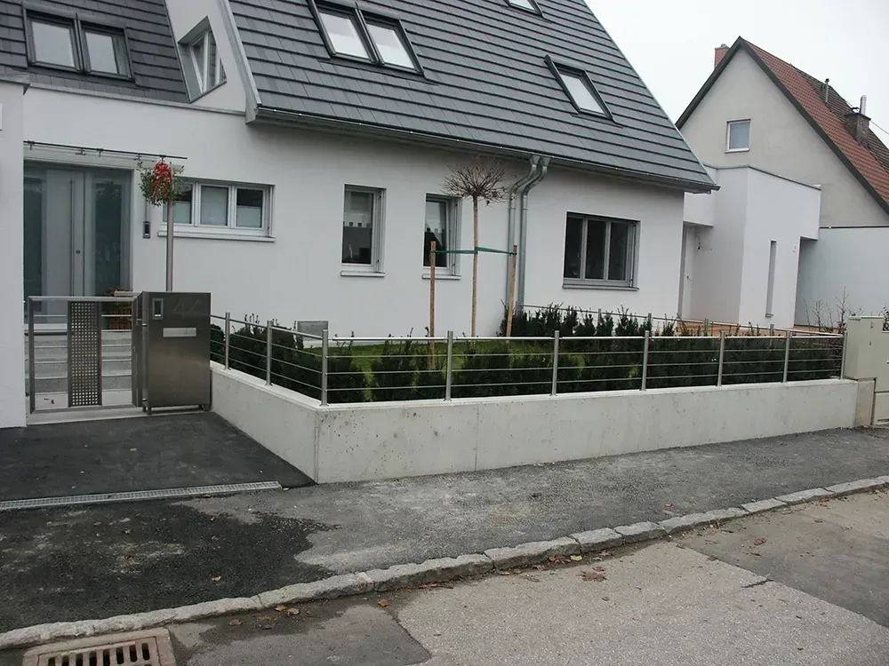 Ein weißes Haus mit einem Zaun davor