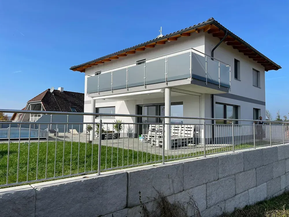 Ein Haus mit einem Balkon und einem Zaun darum