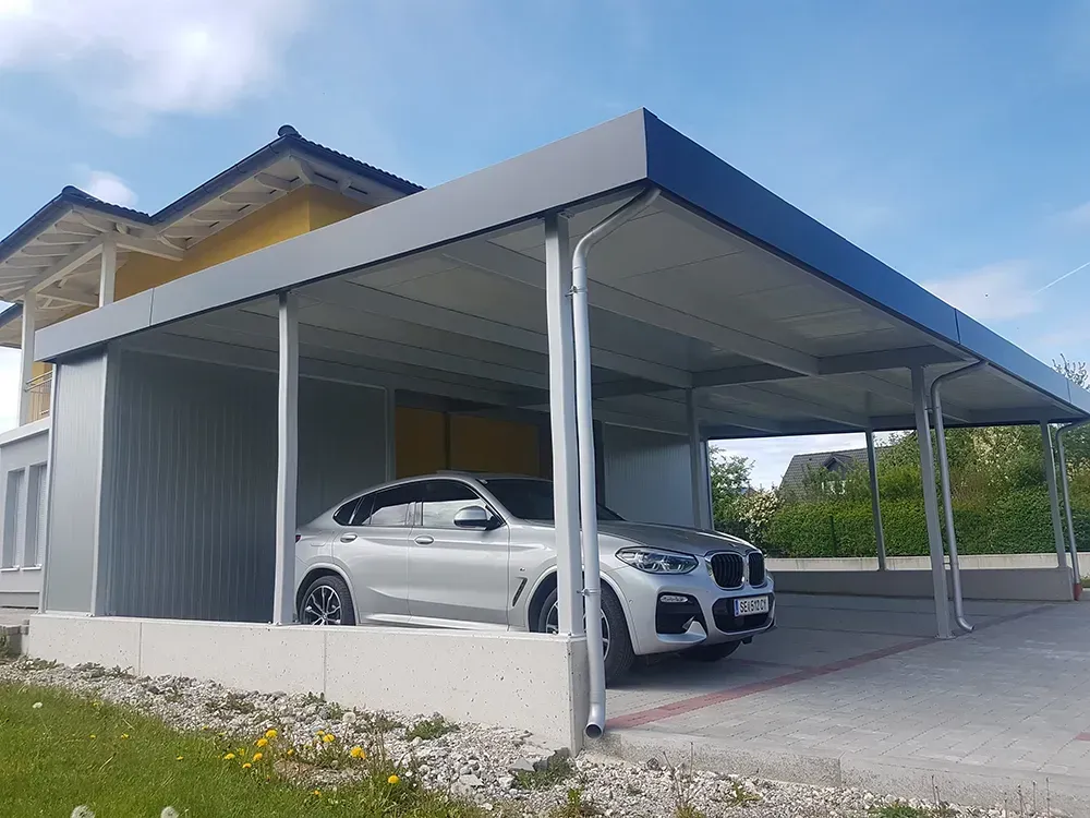 Ein Auto ist unter einem Carport vor einem Haus geparkt.