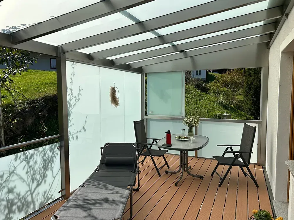 Eine Terrasse mit Tisch und Stühlen unter einem Baldachin.