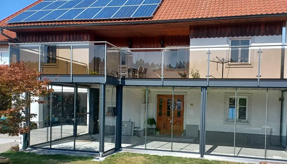 Ein Haus mit Balkon und Sonnenkollektoren auf dem Dach.