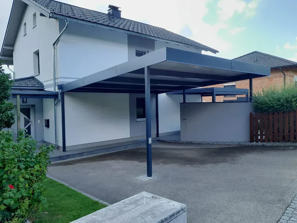 Ein weißes Haus mit einem Carport davor.